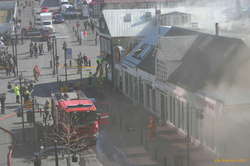 The firemen remove a stack of gas bottles
