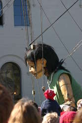 The giantess stoops down to talk to someone
